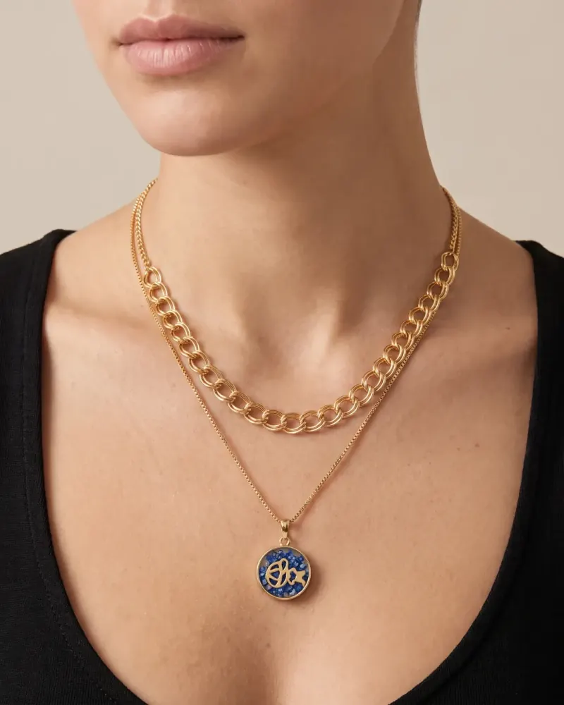 Colar duplo dourado com pingente azul no colo